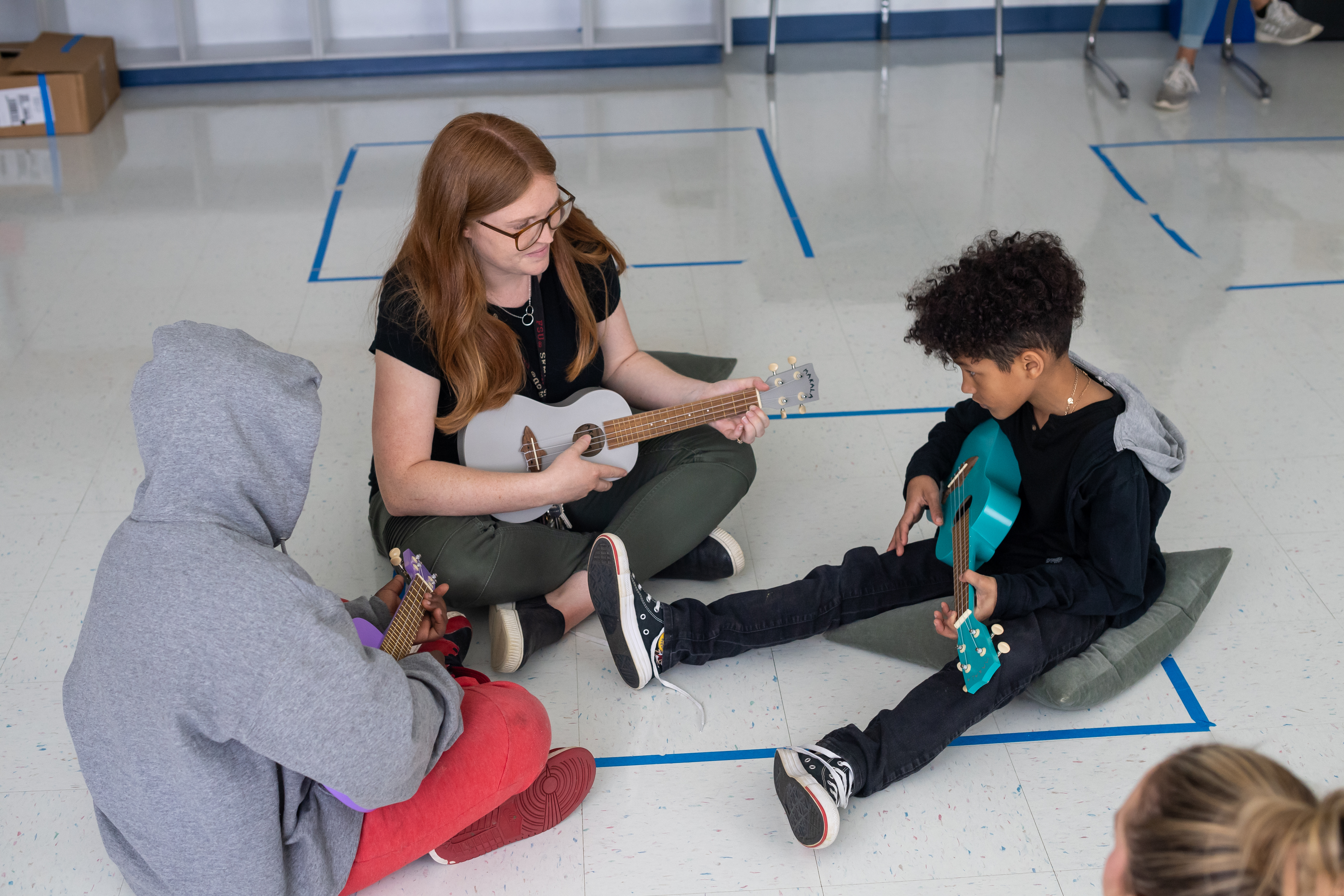 Students play the ukulele in music therapy class. 